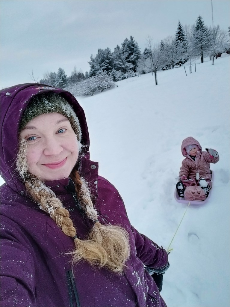 Äiti ja lapsi pulkkamäessä