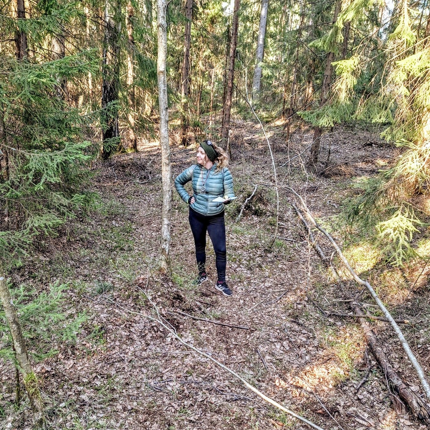Suunnistaja metsän keskellä ihmettelemässä