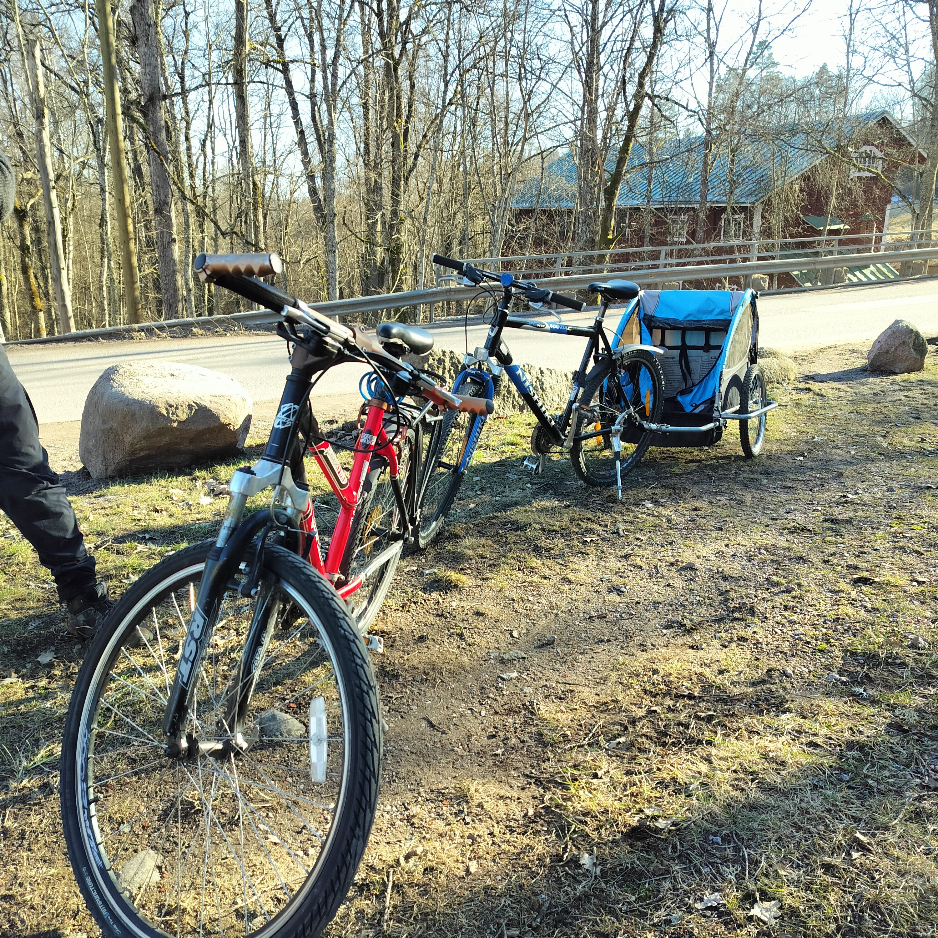 Kaksi maastopyörää ja lasten pyöräkärry keväisessä luonnossa