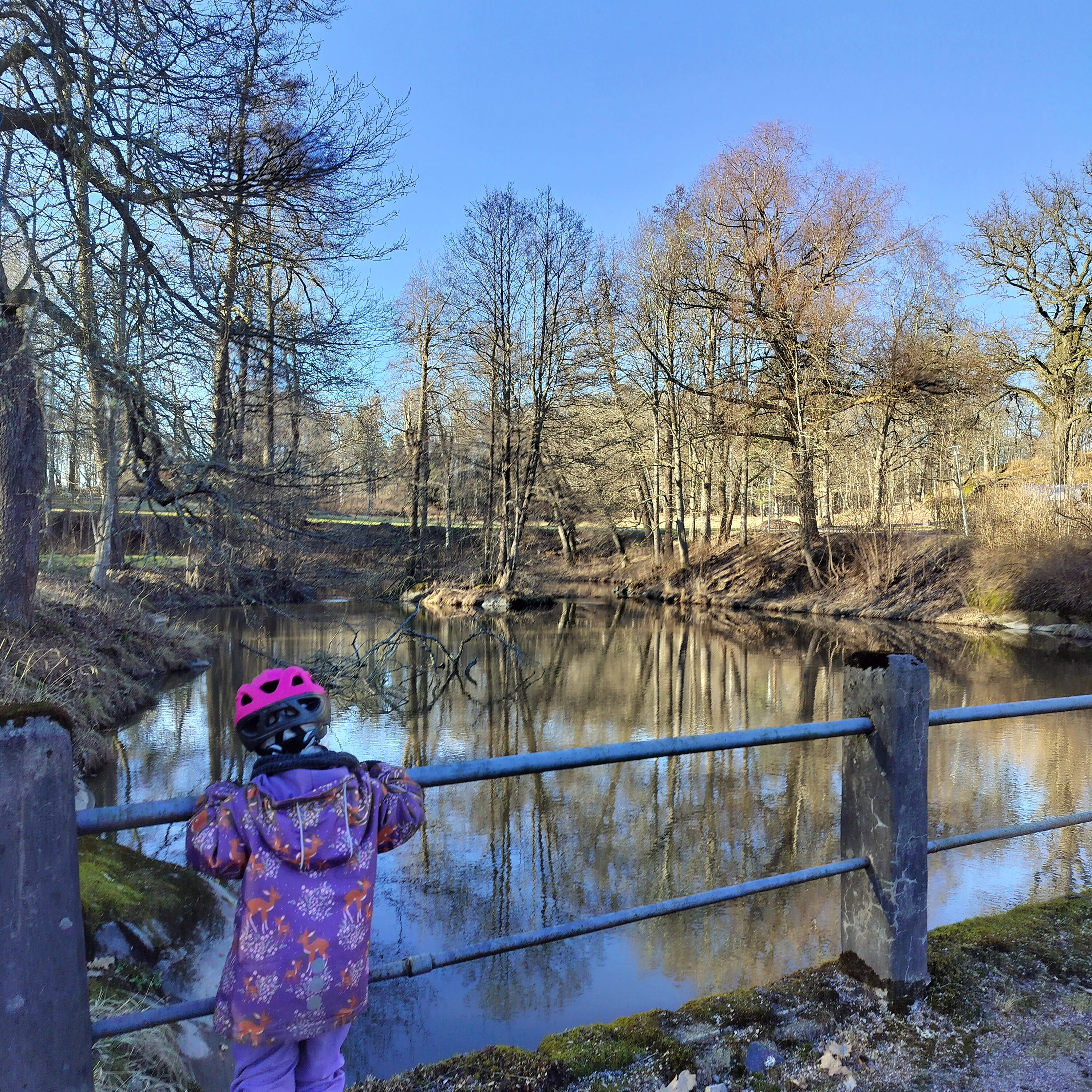Taapero katselee vettä pyöräilykypärä päässään