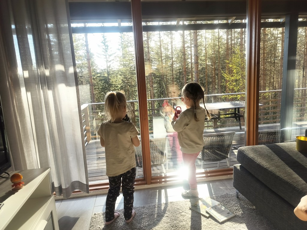 Lapset katsovat metsämaisemaa aamuauringon paisteessa