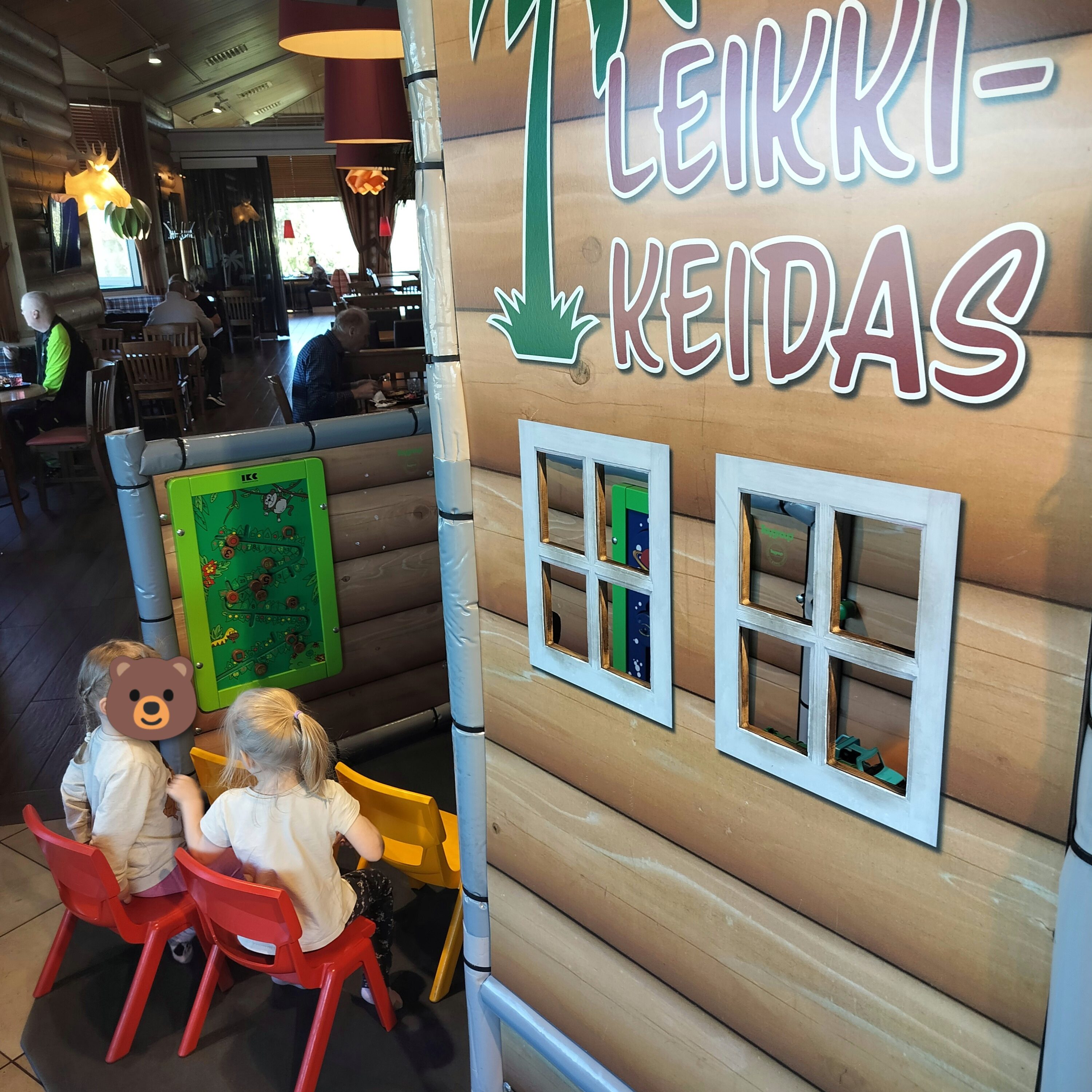 Matkakeitaan leikkinurkaus jossa istuu kaksi lasta. 