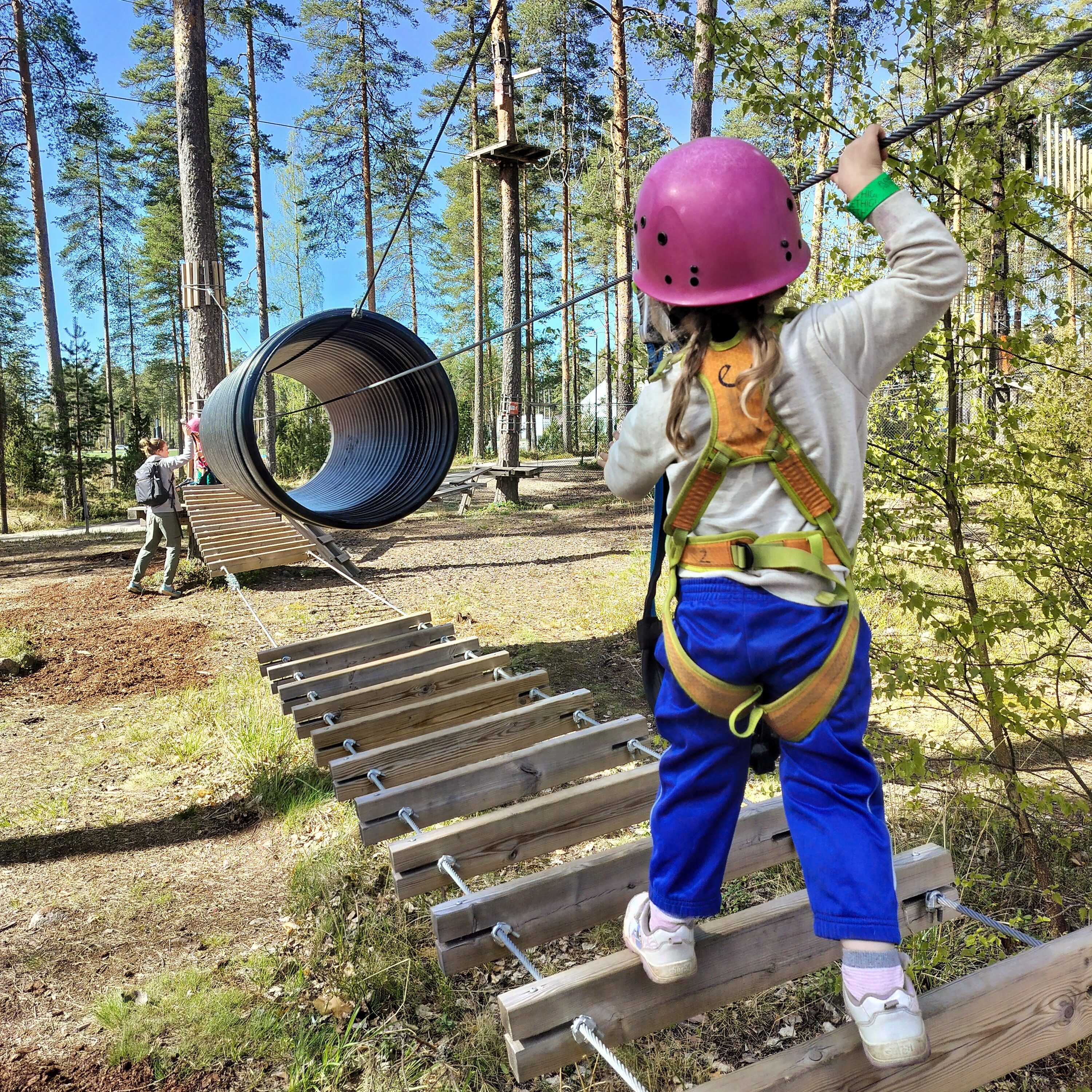 3-vuotias lapsi kiipeää seikkailupuiston radalla