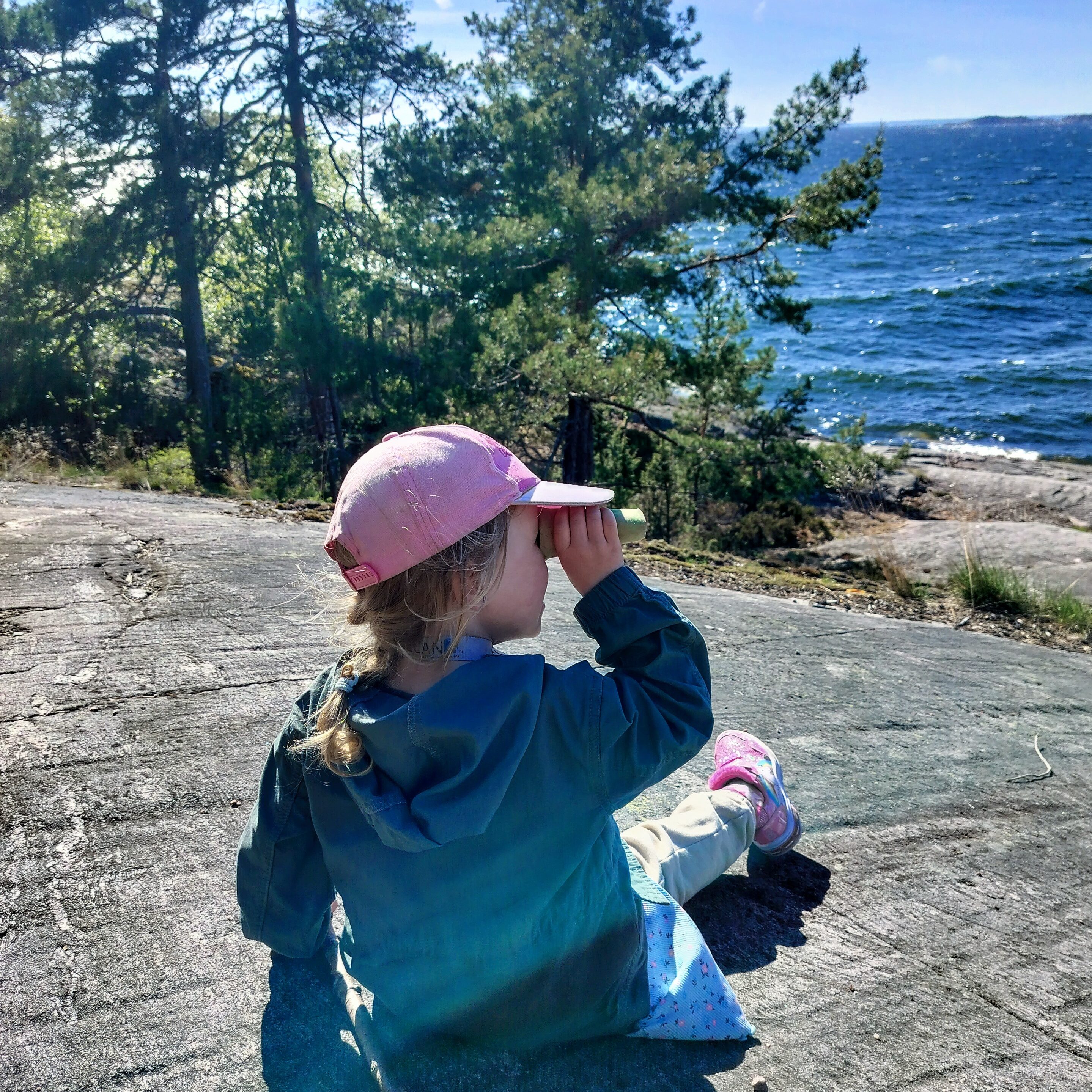 Lapsi katselee merellä lintuja pahvikiikarin läpi