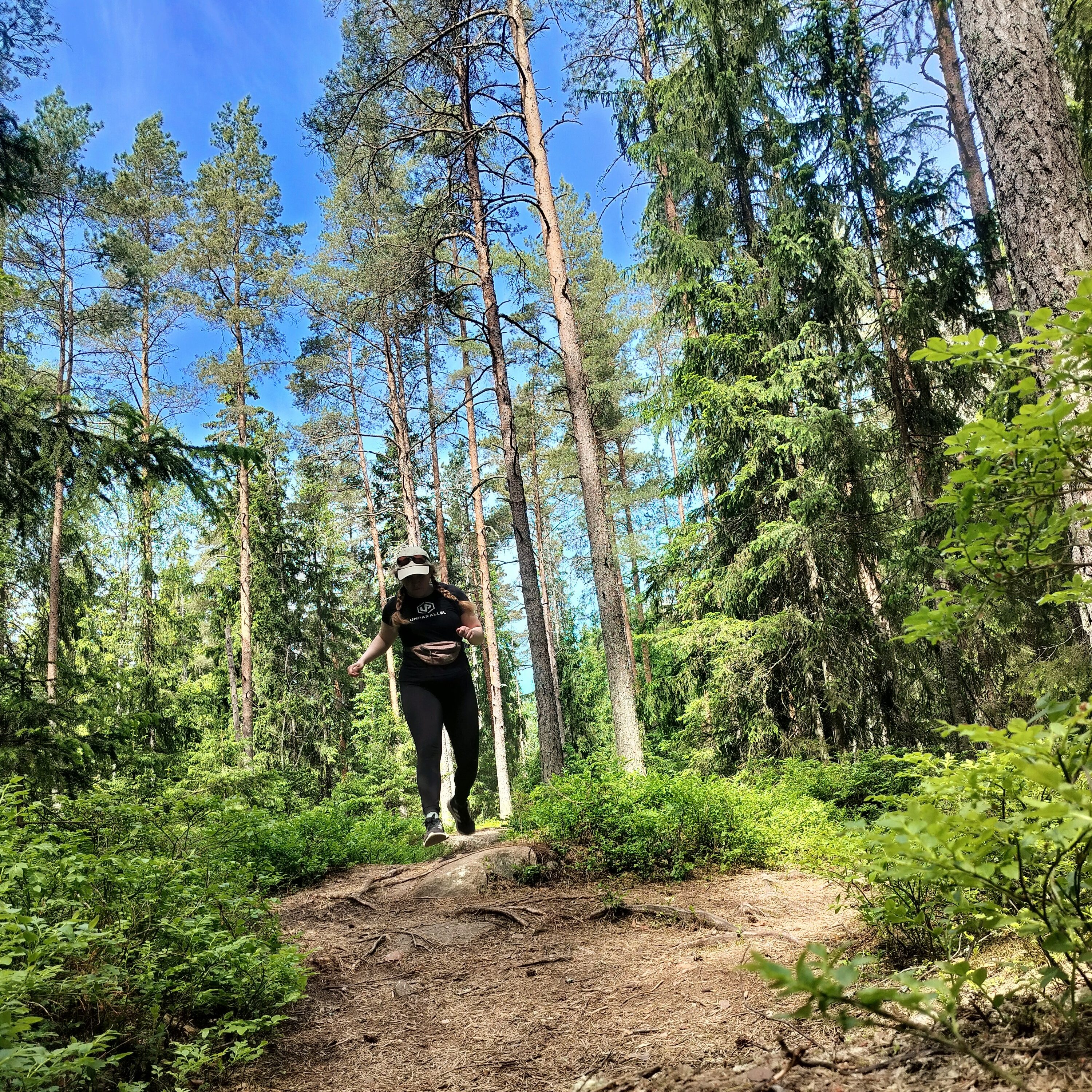 Nainen juoksee polulla metsässä