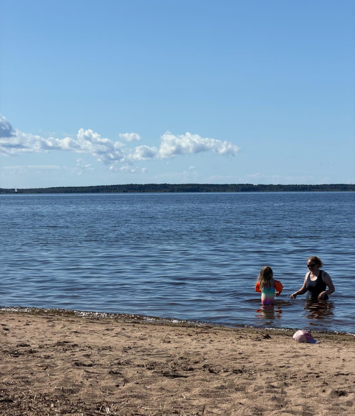 Nainen ja lapsi uimassa Nallikarin hiekkarannalla Oulussa.